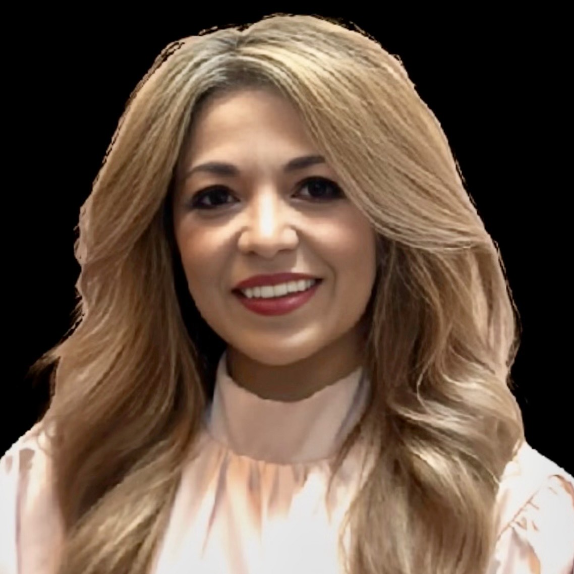 Smiling woman with long, wavy blonde hair wearing a light pink blouse against a black background.
